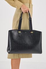 Profile view of model wearing the Oroton Anika Texture 13" Day Bag in Black Croc and Embossed Croc Leather for Women