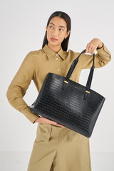 Profile view of model wearing the Oroton Anika Texture 15" Day Bag in Black Croc and  for Women