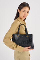 Profile view of model wearing the Oroton Anika Texture Small Day Bag in Black Croc and Embossed Croc Leather for Women