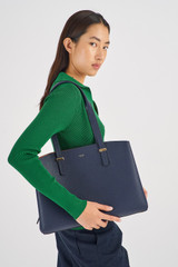 Profile view of model wearing the Oroton Anika 13" Day Bag in Dark Navy and Pebble Leather for Women