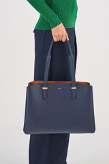Profile view of model wearing the Oroton Anika 13" Day Bag in Dark Navy and Pebble Leather for Women