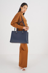 Profile view of model wearing the Oroton Anika 15" Day Bag in Dark Navy and Pebble Leather for Women