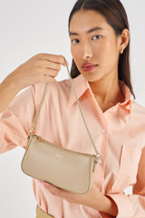 Profile view of model wearing the Oroton Inez Chain Wristlet in Fawn and  for Women