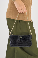 Profile view of model wearing the Oroton Inez Texture Chain Wristlet in Black Croc and  for Women