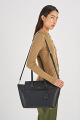 Profile view of model wearing the Oroton Iris Medium Day Bag in Black/Black and Pebble Leather for Women