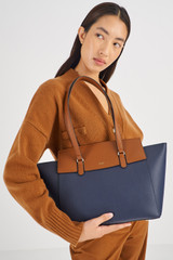 Profile view of model wearing the Oroton Iris Medium Day Bag in Dark Navy/Cinnamon and Pebble Leather for Women