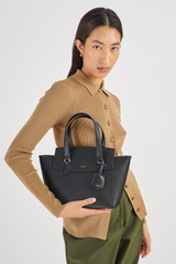 Profile view of model wearing the Oroton Iris Small Day Bag in Black/Black and Pebble Leather for Women