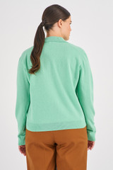 Profile view of model wearing the Oroton Merino Relaxed Polo in Peppermint and 100% Merino Wool for Women