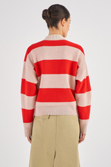 Profile view of model wearing the Oroton Merino Stripe Rugby Knit in Poppy/Peach and 100% Merino Wool for Women