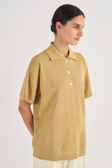 Profile view of model wearing the Oroton Mesh Stitched Polo in Raffia and 83% Viscose, 17% Polyester for Women