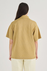 Profile view of model wearing the Oroton Mesh Stitched Polo in Raffia and 83% Viscose, 17% Polyester for Women