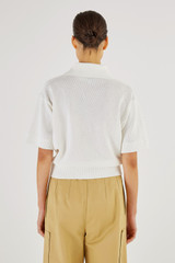 Profile view of model wearing the Oroton Mesh Stitch Polo in White and 83% Viscose 17% Polyester for Women