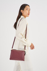 Profile view of model wearing the Oroton Sadie Crossbody in Merlot and Pebble Leather for Women