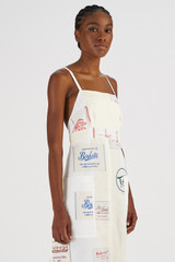 Profile view of model wearing the Oroton Patch Label Apron Dress in Lemon Zest and 100% Linen for Women