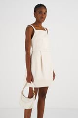 Profile view of model wearing the Oroton Denim Mini Dress in Cream and 100% Cotton for Women