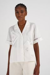 Profile view of model wearing the Oroton Lace Detail Camp Shirt in Antique White and 100% Linen for Women
