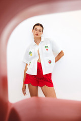 Profile view of model wearing the Oroton Broderie Short in Poppy and 100% Linen for 