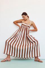 Profile view of model wearing the Oroton Capri Stripe Sundress in Iced Chocolate and 100% Linen for Women