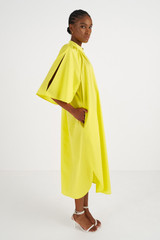 Profile view of model wearing the Oroton Contrast Belt Dress in Honey Dew and 100% Cotton for Women