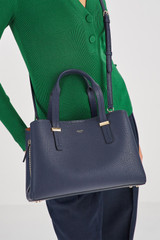 Profile view of model wearing the Oroton Anika Small Day Bag in Dark Navy and Pebble Leather for Women