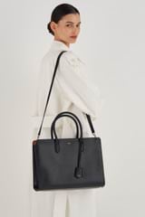 Profile view of model wearing the Oroton Muse 15" Worker Tote in Black and Saffiano Leather for Women