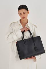 Profile view of model wearing the Oroton Muse 15" Worker Tote in Black and Saffiano Leather for Women