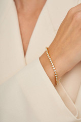 Profile view of model wearing the Oroton Juniper Bracelet in Gold/Clear and Brass Base With 18CT Gold Plating for Women