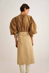 Profile view of model wearing the Oroton Utility Skirt in Sandstone and 97% Cotton, 3% Elastane for Women