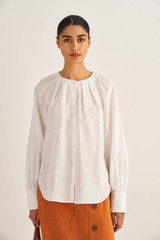 Profile view of model wearing the Oroton Ruffle Yoke Blouse in Antique White and 100% Linen for Women