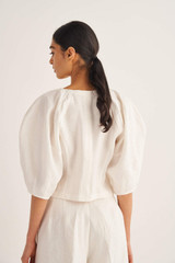 Profile view of model wearing the Oroton Sculptured Top in Eggshell and 100% Linen for Women