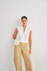 Profile view of model wearing the Oroton Flat Front Pant in Wheat and 100% Cotton for Women
