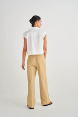 Profile view of model wearing the Oroton Flat Front Pant in Wheat and 100% Cotton for Women