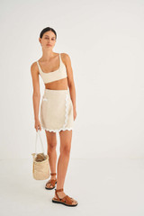 Profile view of model wearing the Oroton Short Wrap Skirt in Ecru and 100% Linen for Women