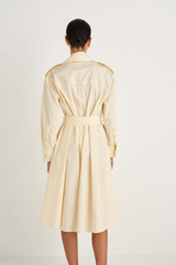 Profile view of model wearing the Oroton Trench Dress in Butter and 100% Cotton for Women
