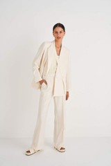 Profile view of model wearing the Oroton Slouch Pant in Marshmallow and 53% Polyester 43% Wool 4% Elastane for Women