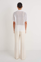 Profile view of model wearing the Oroton Short Sleeve Lace Shirt in White and 67% Nylon 33% Cotton for Women