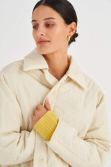 Profile view of model wearing the Oroton Quilted Puffer Coat in Jute and 100% Polyester for Women