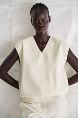 Profile view of model wearing the Oroton Crop Crew Knit in Marshmallow and 77% Viscose 23% Polyester for Women