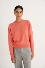 Profile view of model wearing the Oroton Long Sleeve Cashmere Crew Neck in Sherbet and 100% Cashmere for Women