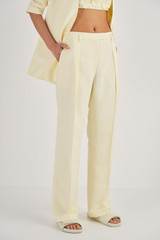 Profile view of model wearing the Oroton Pleat Detail Pant in Lemon Butter and 58% Viscose, 42% Linen for Women