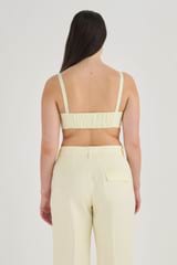 Profile view of model wearing the Oroton Lace Poppy Bandeau in Lemon Butter and 100% Linen for Women