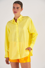Profile view of model wearing the Oroton Silk Long Sleeve Shirt in Vibrant Yellow and 100% Silk for Women