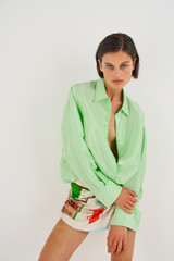 Profile view of model wearing the Oroton Silk Long Sleeve Shirt in Pear and 100% Silk for Women