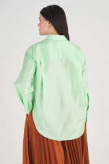 Profile view of model wearing the Oroton Silk Long Sleeve Shirt in Pear and 100% Silk for Women