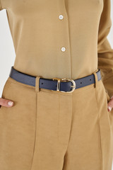 Profile view of model wearing the Oroton Inez Reversible Belt in Navy/Fawn and Saffiano for Women