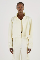 Profile view of model wearing the Oroton Crop Trench in Cream and 77% Cotton 23% Linen for Women
