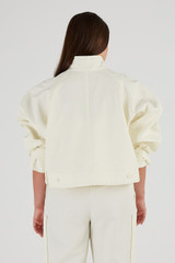 Profile view of model wearing the Oroton Crop Trench in Cream and 77% Cotton 23% Linen for Women