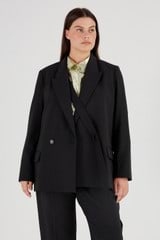 Profile view of model wearing the Oroton Double Breasted Blazer in Black and 53% Polyester 42% Wool 5% Elastane for Women