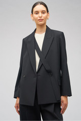 Profile view of model wearing the Oroton Double Breasted Blazer in Black and 53% polyester, 42% virgin wool, 5% elastane for Women