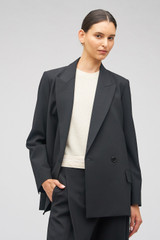 Profile view of model wearing the Oroton Double Breasted Blazer in Black and 53% polyester, 42% virgin wool, 5% elastane for Women